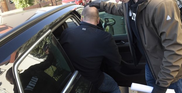 Zadržaný muž si sadá do auta počas dopingovej razie v nemeckom meste Erfurt